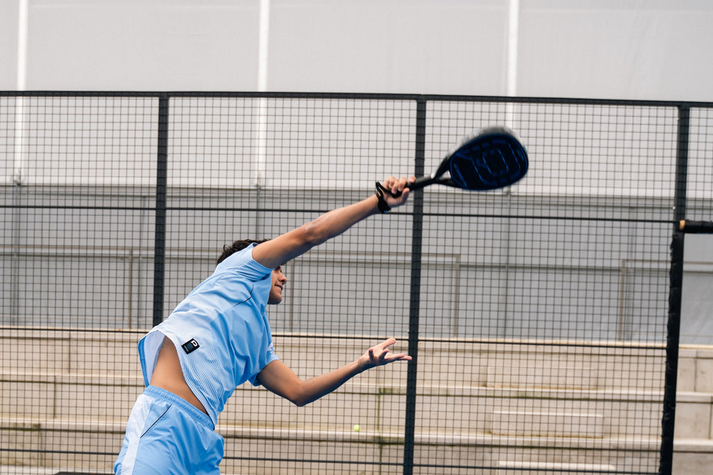 Padel player reaching for an overhead shot with a Pallap racket