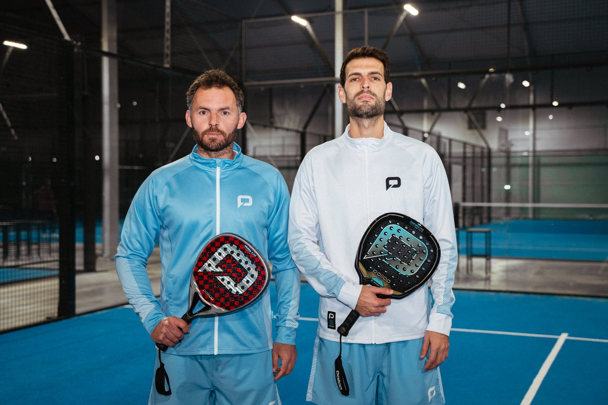 Two men in Pallap padel jackets holding rackets on an indoor court