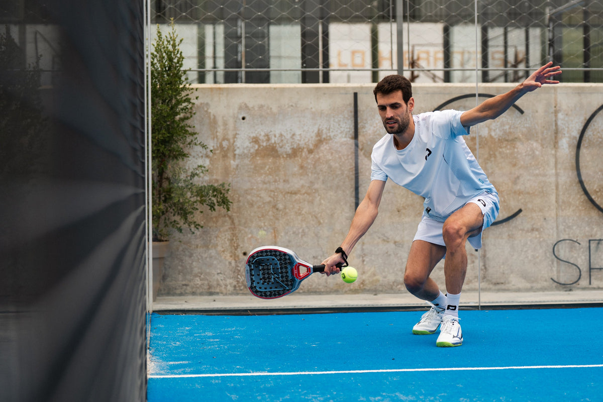 Padel player hitting a low ball with a Pallap Velocity racket