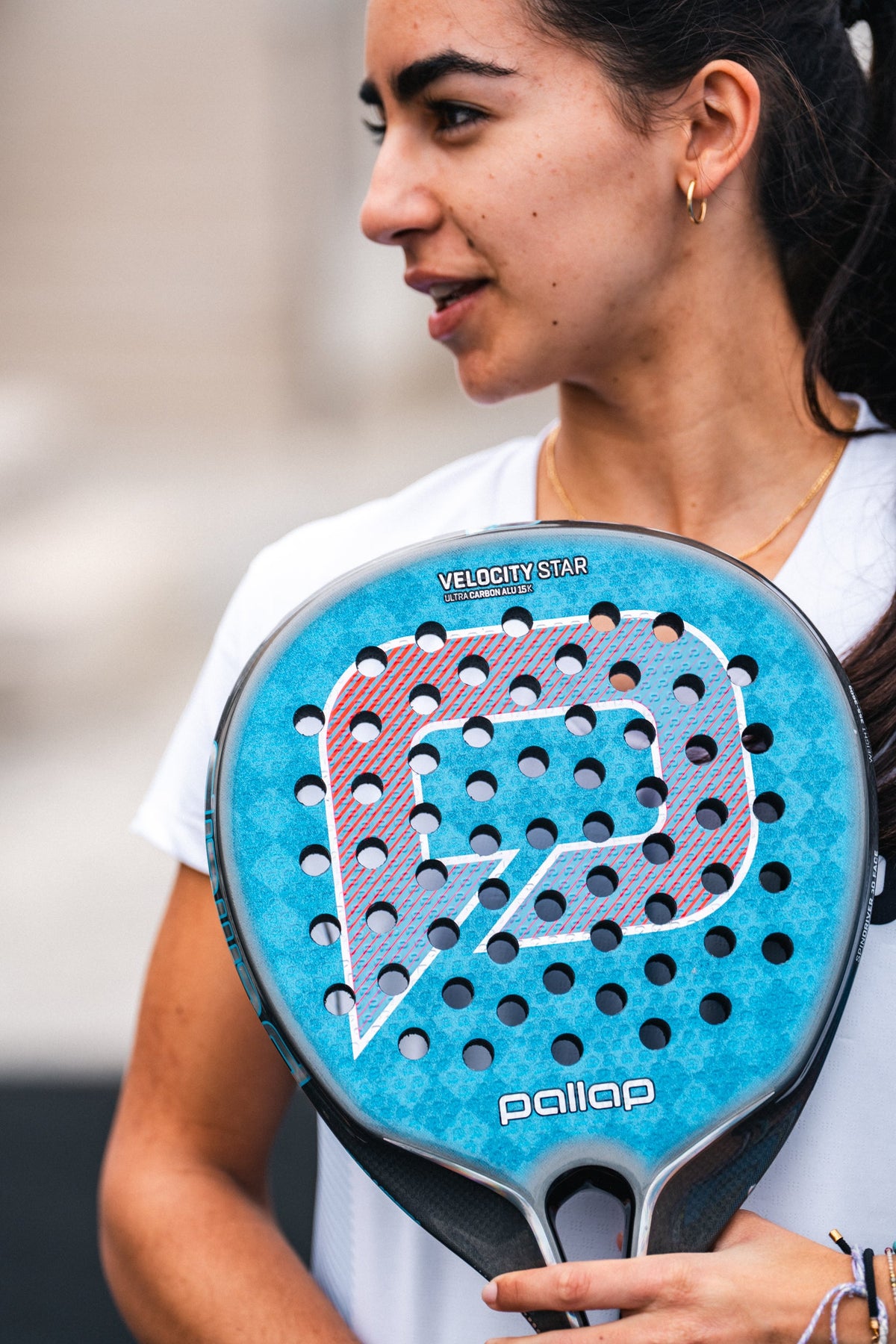 Woman holding a Pallap padel racket on court