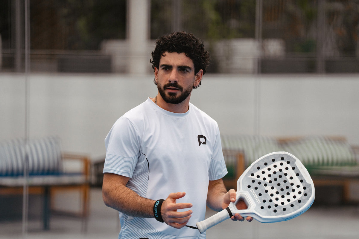Smiling padel player holding a Pallap racket on court